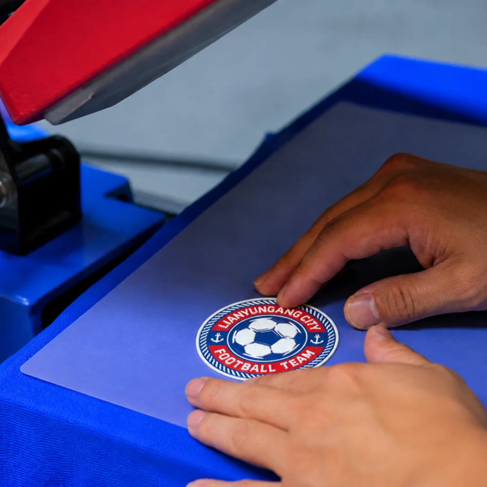3D Raised Logo Heat Press Application 3D raised logo being aligned on a heat press machine for apparel transfer